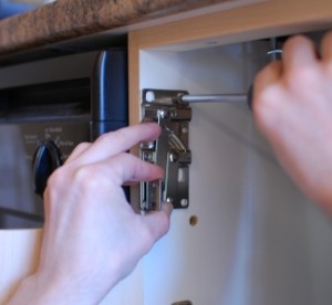 Installing kitchen drawer hinges.